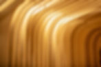 Curved wooden arches form a tunnel-like structure, illuminated by warm lighting, creating a serene and abstract architectural scene.